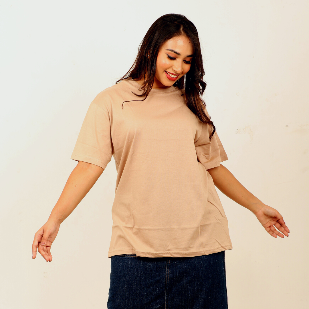 A woman posing with a Beige colored Oversized t-shit